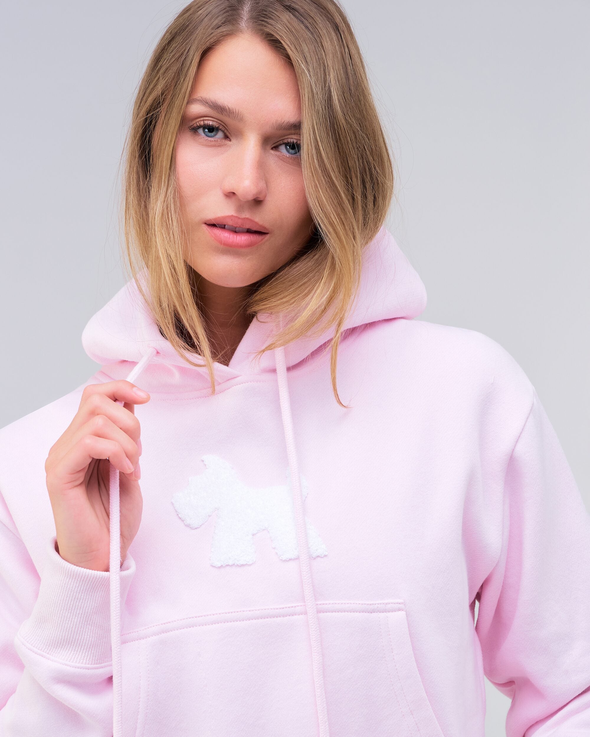 Emely cropped pullover hoodie in baby pink, close-up of front logo and pocket