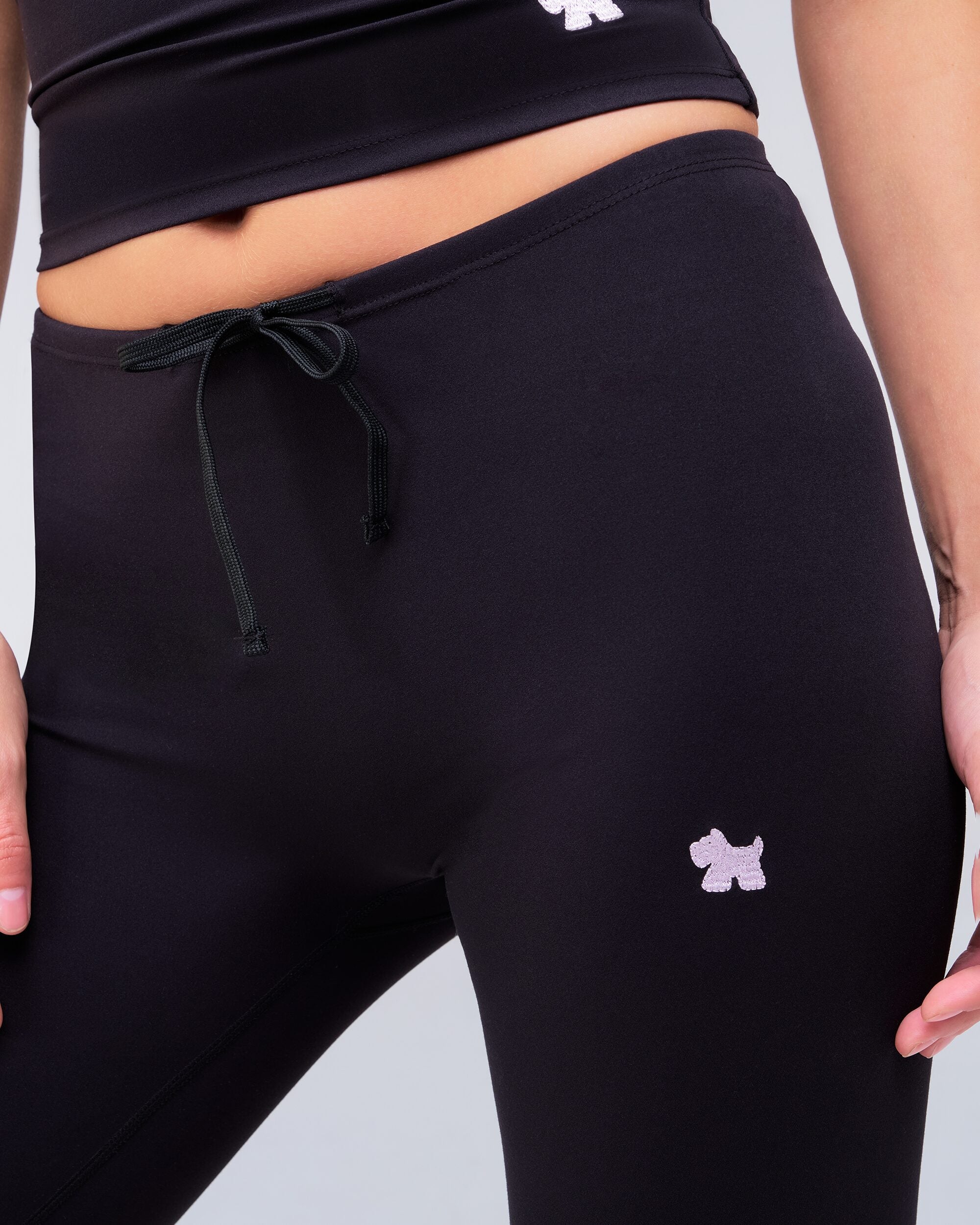 Adley fitted low rise drawstring flare pants in black, close-up of drawstring waistband and logo