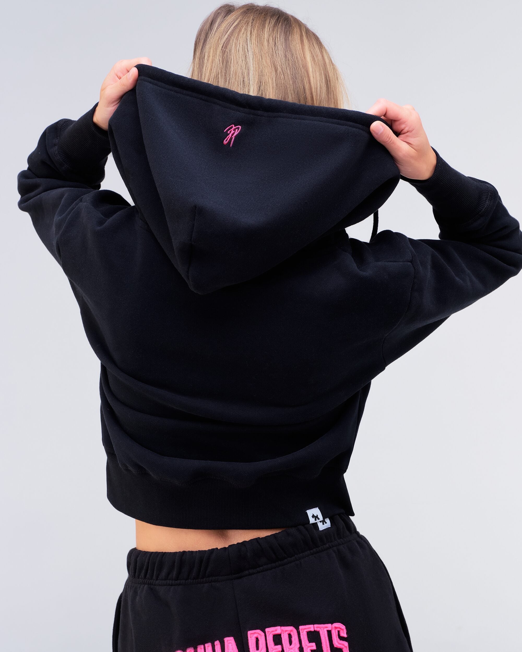Paige relaxed-fit zip-up hoodie in black with pink logo, back view of hood