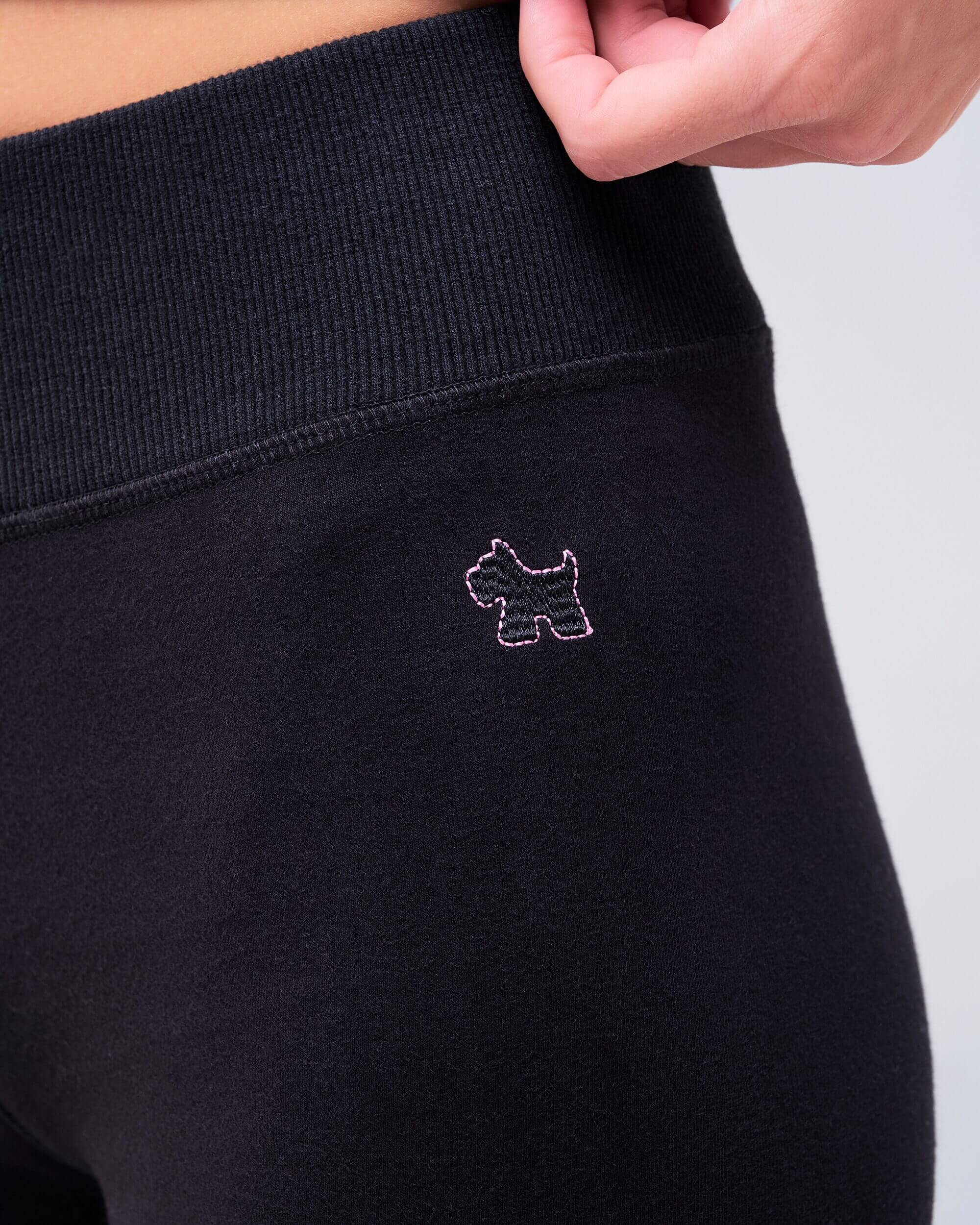 Edith fitted low rise flare pant in black, close-up of waistband logo