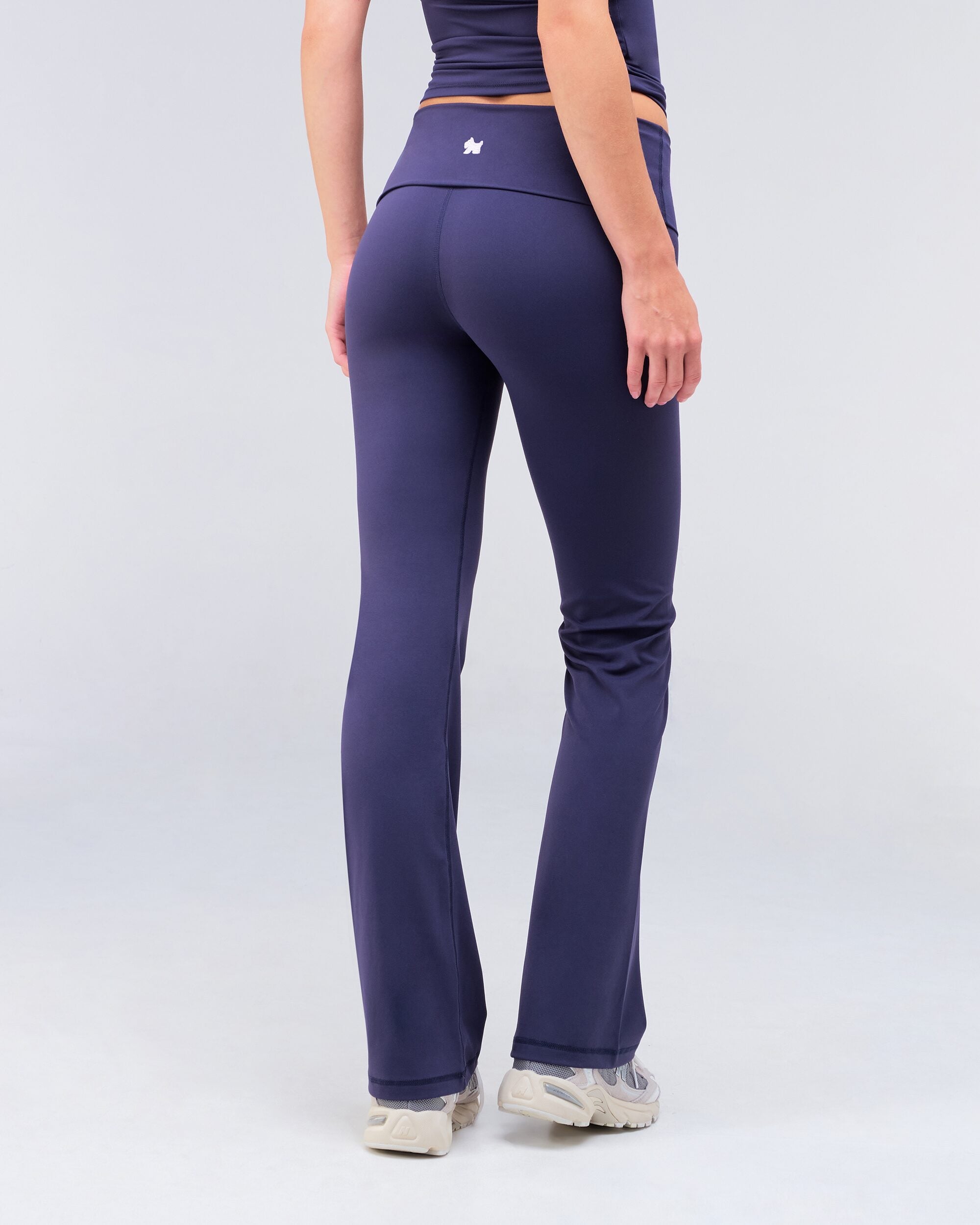Andy fitted turnover flare pant in navy, three-quarter back view walking